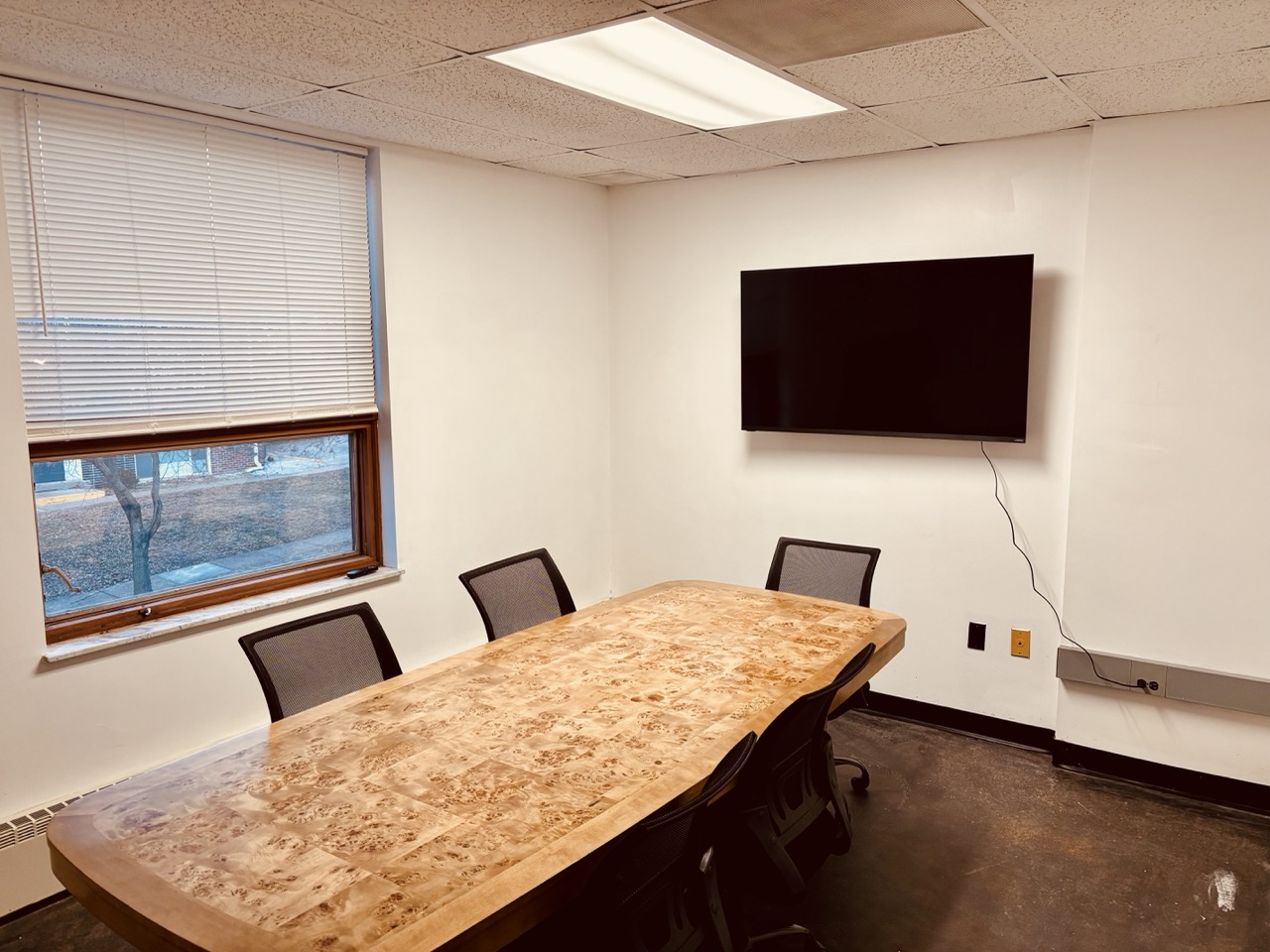Ren AI Lab conference room with burl wood table and ergonomic chairs